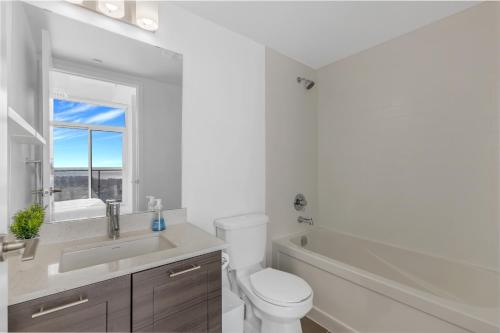 a white bathroom with a toilet and a sink at *Luxury 2BR-2BA, High Floor, Unobstructed Lake View* in Toronto