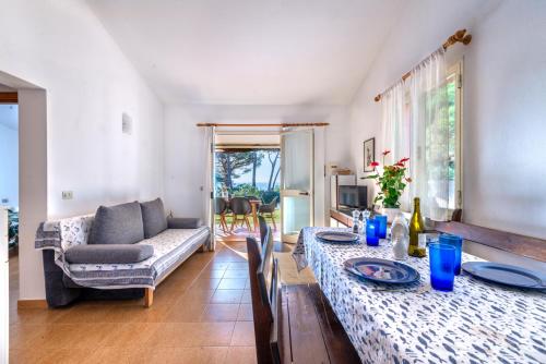 a living room with two tables and a couch at Villetta Norsi in Capoliveri
