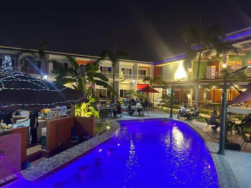 una piscina por la noche con gente sentada alrededor de un restaurante en Blue Hotel and Resort, en Porac