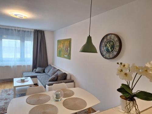 a living room with a couch and a clock on the wall at Apartman Lory, Zagreb, Downtown, with own parking in the garage in Zagreb