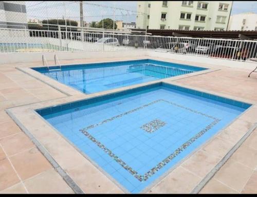 uma piscina com água azul num edifício em Apt inteiro bem localizado com Wi-Fi e aceita Pets em Aracaju
