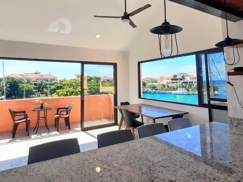 a living room with a table and chairs and a large window at Penthouse, Ocean & Marina vws, Great 4 Remote Work in Puerto Aventuras
