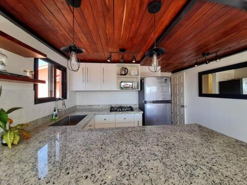 a kitchen with white cabinets and a wooden ceiling at Penthouse, Ocean & Marina vws, Great 4 Remote Work in Puerto Aventuras