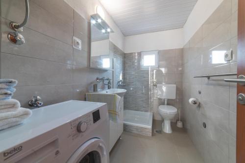a white bathroom with a washing machine in it at Family friendly house with a swimming pool Veliki Brocanac, Zagora - 22666 in Klis