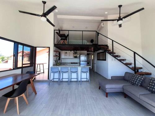a living room with a couch and a staircase in a house at Penthouse, Ocean & Marina vws, Great 4 Remote Work in Puerto Aventuras