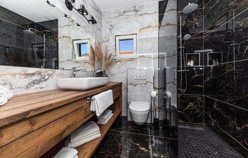 La salle de bains est pourvue d'un lavabo et d'une douche. dans l'établissement Family friendly house with a swimming pool Vrsine, Trogir - 22668, à Marina