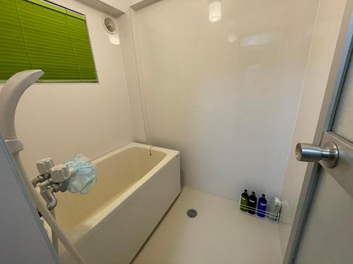a bathroom with a bath tub and a window at 高原マンション 202 in Matsuyama