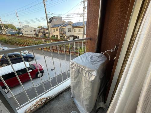 a balcony with a trash can and a view of a street at 高原マンション 202 in Matsuyama