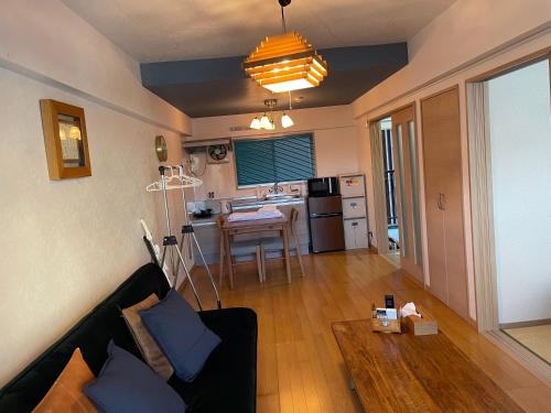 a living room with a couch and a kitchen at 高原マンション 202 in Matsuyama