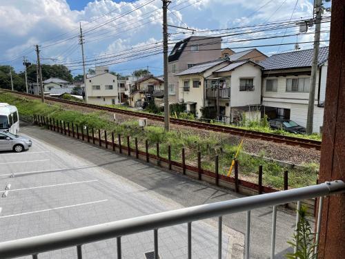 a car driving down a street next to a train track at 高原マンション 202 in Matsuyama