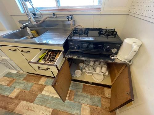 a kitchen with a sink and a stove at 高原マンション 205 in Matsuyama