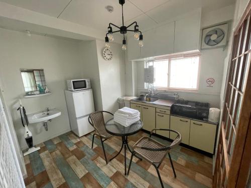 a kitchen with a table and chairs and a sink at 高原マンション 205 in Horinouchichō