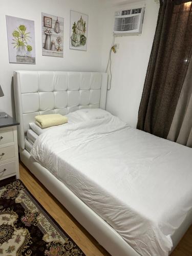 un letto bianco in una stanza con finestra di Arezzo Davao GZJ condotelle 300mbps wifi a Davao