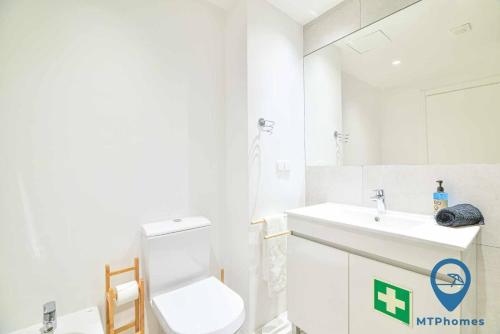 uma casa de banho branca com um WC e um lavatório em Apartamento ValeMangude Piscina e Praia A em Albufeira