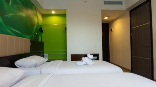 a room with two beds with a teddy bear sitting on them at PrimeBiz Cikarang in Cikarang