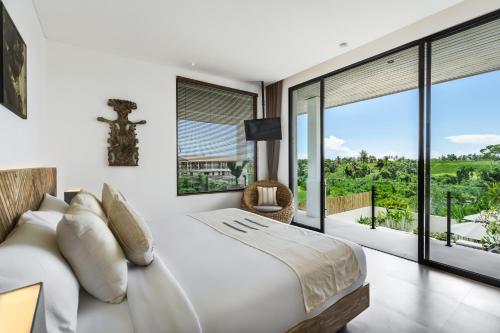 een slaapkamer met een wit bed en grote ramen bij Villa Leeloo by BaliSuperHost in Canggu