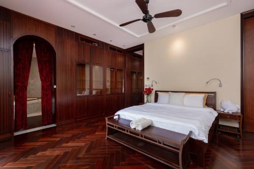 a bedroom with a bed and a ceiling fan at OrangeBlue villa near Beach Pool free Vung Tau Vietnam in Vung Tau