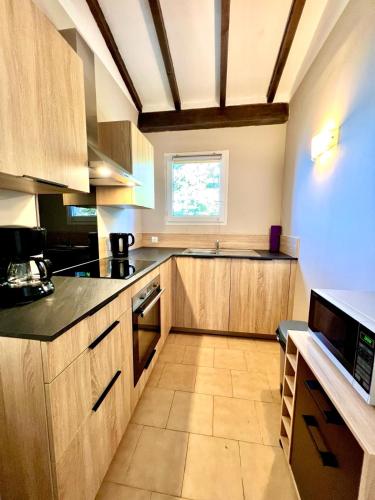 a large kitchen with wooden cabinets and a window at Résidence Padovani Marina in Calcatoggio