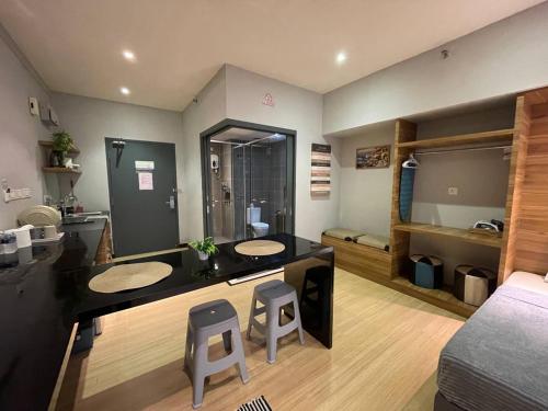 a room with a kitchen with two counters and two stools at Aeropod Sovo ,Wifi ,5 minit from Airport in Kota Kinabalu