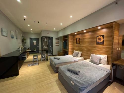 1 dormitorio con 2 camas, escritorio y cocina en Aeropod Sovo ,Wifi ,5 minit from Airport, en Kota Kinabalu