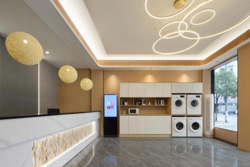 una cocina con lavadoras y secadoras en un edificio en Anlan Hotel Shangrao Wuyuan Cultural Plaza en Wuyuan