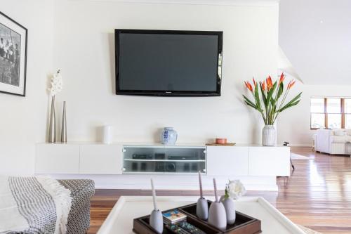 a living room with a flat screen tv on a wall at The Hampton Lodge with private pool on 25 acres in Port Douglas