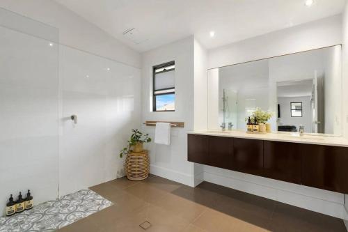 een badkamer met een grote wastafel en een spiegel bij Zinc Casuarina in Casuarina