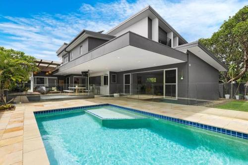 a house with a swimming pool in front of it at Zinc Casuarina in Casuarina