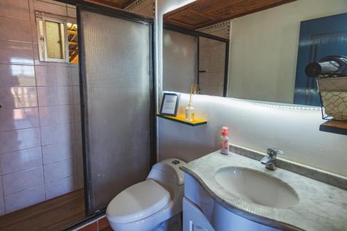 y baño con lavabo, aseo y espejo. en Hermosa Casa OlaSurf Punta de Lobos & Marbox 7 en Pichilemu