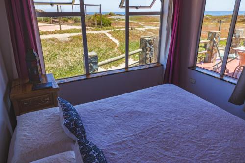 une chambre avec un lit avec vue sur l'océan dans l'établissement The Red Roof House WiFi, à Pichilemu