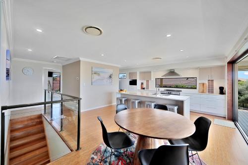a kitchen and dining room with a table and chairs at Nudibranch House in Bargara