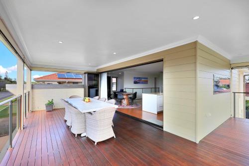 a patio with a table and chairs on a deck at Nudibranch House in Bargara