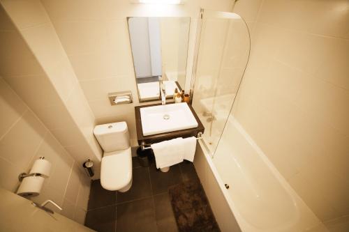 a bathroom with a toilet and a sink and a mirror at Havre de paix boisé à St François in Saint-François