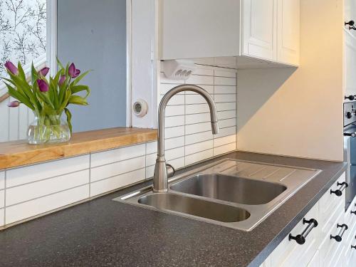 a kitchen with a sink and a vase of flowers at Holiday home ANNEBY II in Aneby