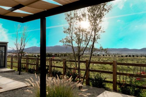 a view from the porch of a home with a fence and a field at MiLu in El Porvenir