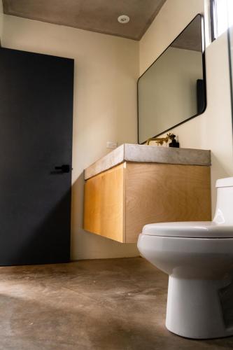 a bathroom with a white toilet and a mirror at MiLu in El Porvenir