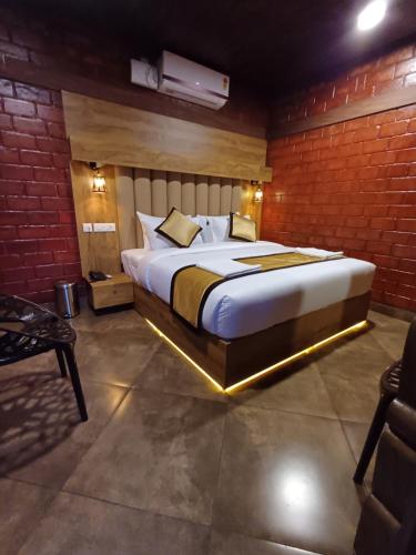 a bedroom with a large bed in a brick wall at East West Beach Resorts in Varkala