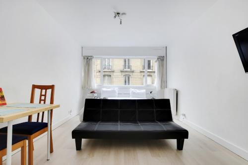 巴黎的住宿－Appartement Alesia，窗户房间里一张黑色的沙发