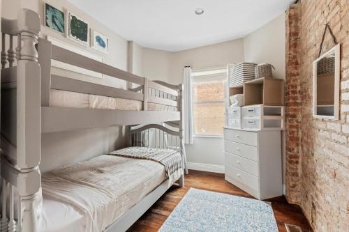 sypialnia z 2 łóżkami piętrowymi i ceglaną ścianą w obiekcie Columbia Heights Home METRO + Shopping + Parking w Waszyngtonie