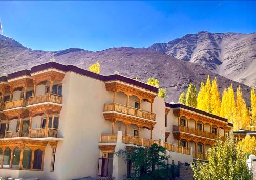 a large building with mountains in the background at The Legacy Alchi in Leh