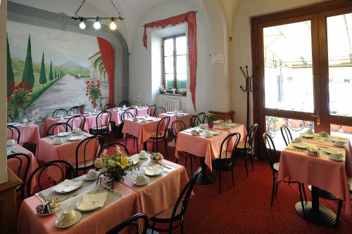une salle à manger avec tables et chaises et nappes roses dans l'établissement Hotel Villa Kinzica, à Pise