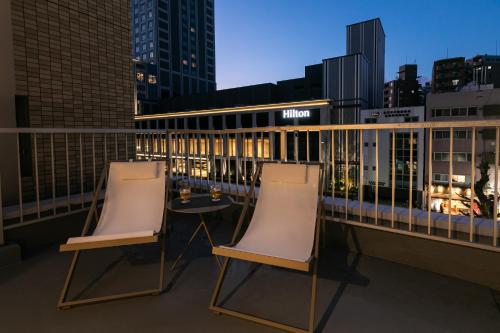 two chairs and a table on a balcony at City Center Villas ゲストハウス35 supported by COCOSTAY in Hijiyamachō