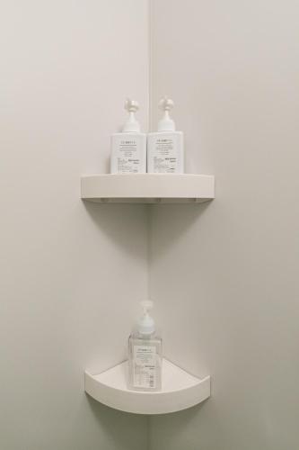 a shelf with two bottles ofodorizers on a wall at City Center Villas ゲストハウス35 supported by COCOSTAY in Hijiyamachō