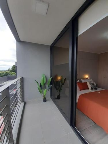 Departamento Centro Plaza 403 في Pitrufquén: غرفة نوم بسرير ونافذة زجاجية كبيرة