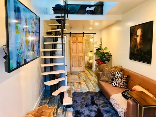 a living room with a couch and a spiral staircase at Luxury City Tiny House in Denver