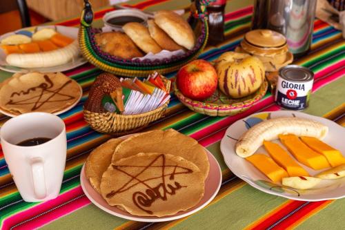 a table topped with plates of food and fruit at Uros TITIKAKA the Best lodge in Puno