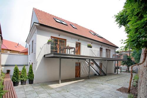 a white house with a balcony and a staircase at Penzion Dobré Časy in Poděbrady