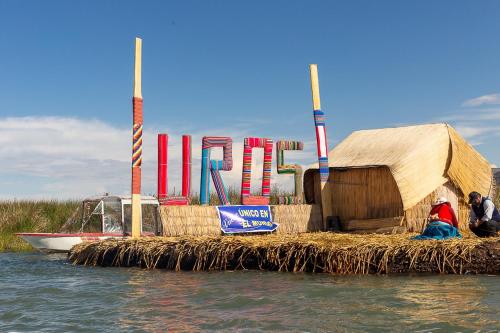 a small house on a floating island in the water at Uros TITIKAKA the Best lodge in Puno