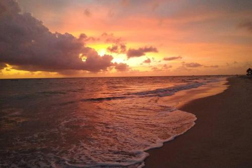 a sunset on a beach with the ocean at Casa aconchegante próxima a Praia de Jaguaribe in Itamaracá