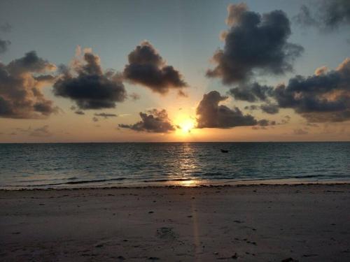 een zonsondergang op een strand met de oceaan bij Casa aconchegante próxima a Praia de Jaguaribe in Itamaracá